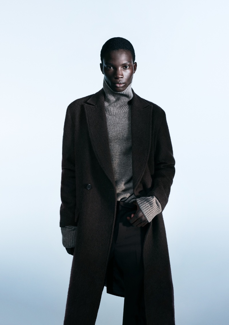 A sleek vision, Dara Gueye sports a long coat for H&M's fall-winter 2023 campaign.