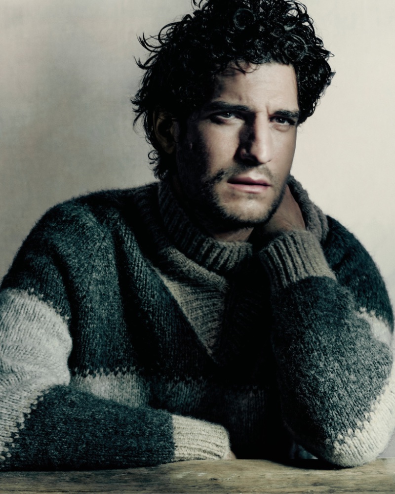 Louis Garrel wears a geometric grey sweater for Giorgio Armani's fall-winter 2023 campaign. 