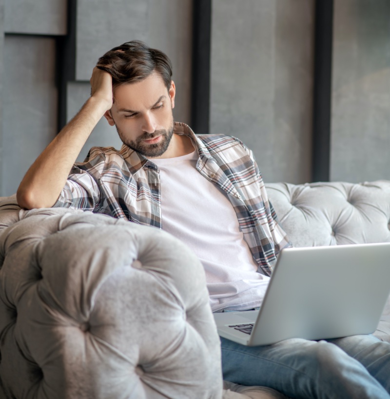Man Sitting on Couch Looking at Laptop » Unlocking Your Perfect Fit: A Guide to Online Shopping Man Sitting on Couch Looking at Laptop
