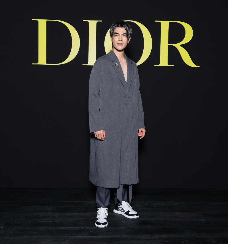 Embracing extra long proportions, Mile Phakphum Romsaithong wears a grey Dior Men poncho. » Robert Pattinson, Apo + More Go Sartorial at Dior Show Embracing extra long proportions, Mile Phakphum Romsaithong wears a grey Dior Men poncho.