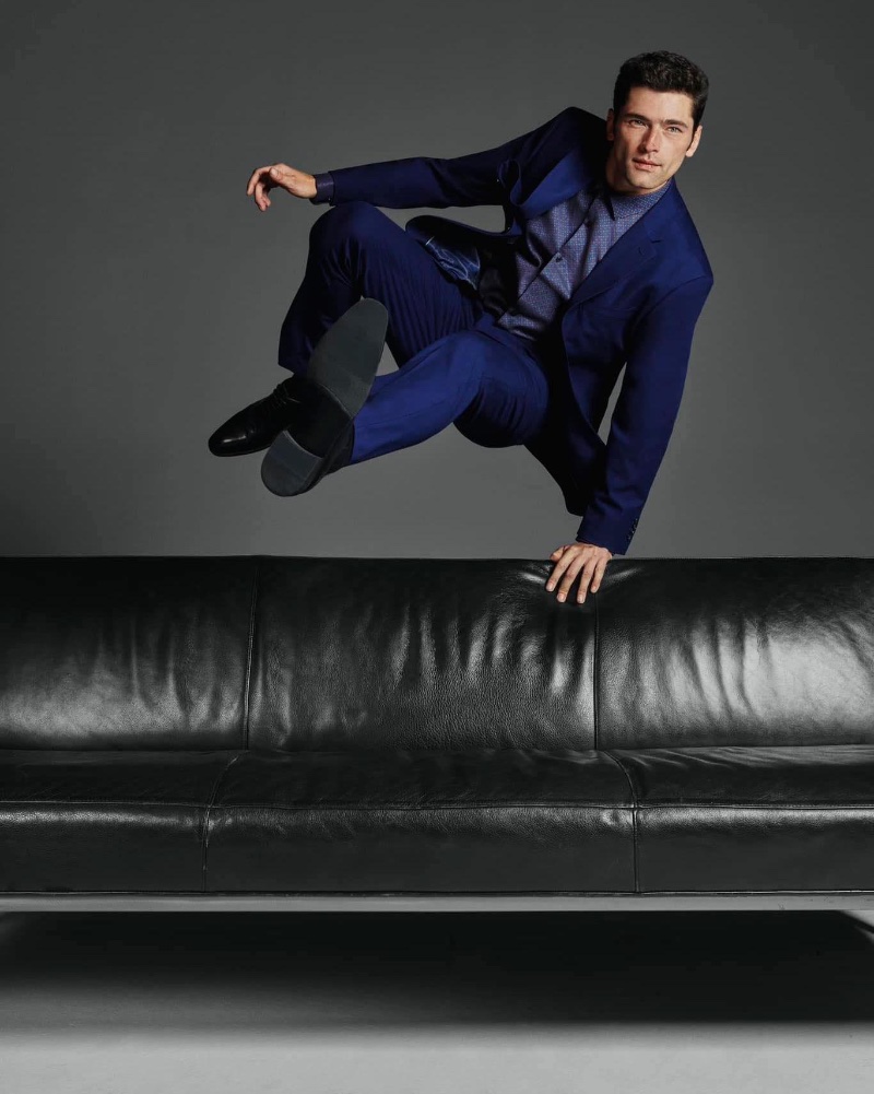 Leaping over a leather couch, Sean O'Pry stands out in a statement blue suit for Perry Ellis' fall-winter 2023 campaign. 
