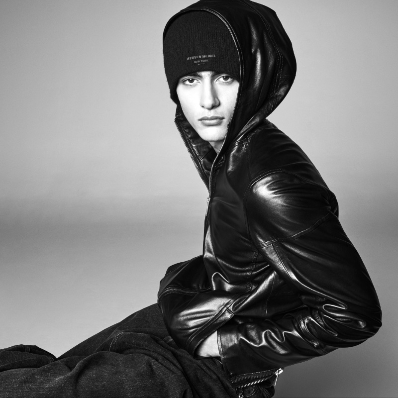 Akbar Shamji sports a modern full-zip hoodie with a beanie and jeans from the Steven Meisel x Zara collection. 