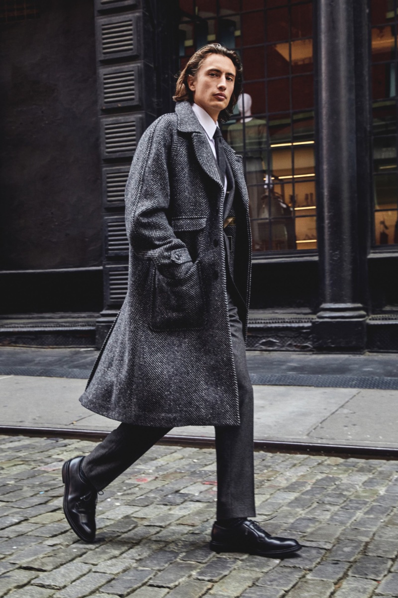 James Turlington models Todd Snyder's Italian wool Balmacaan coat in charcoal herringbone. 