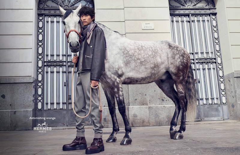 Sanggun Lee poses alongside a horse for Hermès' fall-winter 2023 campaign. 