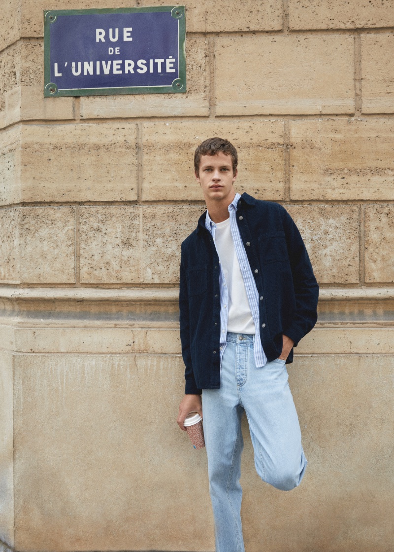 Adrian Planas sports an overshirt, layered with an open oxford shirt and light wash jeans from Mango Teen's fall 2023 collection.