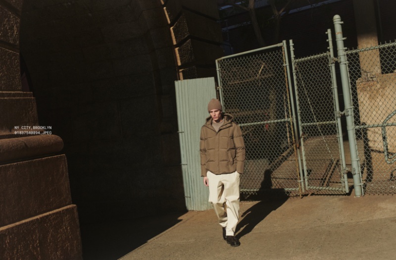 Wearing neutral tones, Joaquín Ibarra sports a puffer jacket with a boxy-fit sweater and darted chino trousers. 