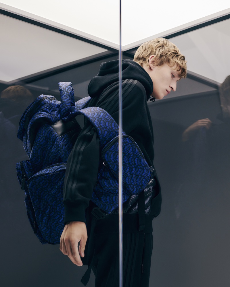 Embracing a sporty winter look, Nikita Stsjolokov rocks a Moncler x adidas Originals three-stripe paneled cotton-jersey hoodie and a logo-print nylon backpack.