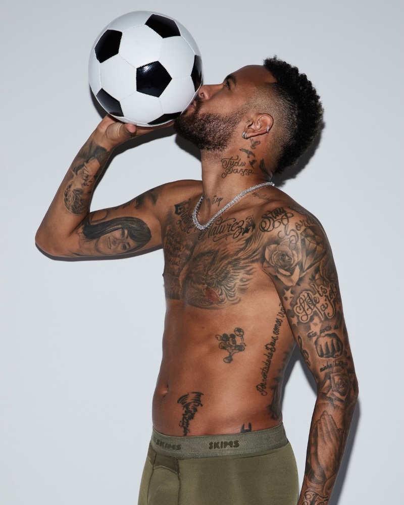 Neymar Jr. kisses a soccer ball as he stars in a campaign for the launch of SKIMS men.