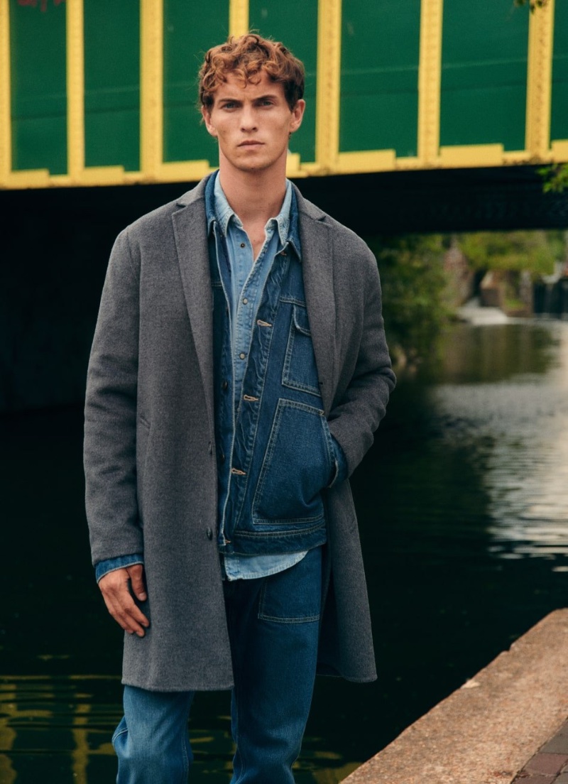 Luc Defont-Saviard layers in a jean jacket, denim shirt, jeans, and coat for Pepe Jeans' fall-winter 2023 campaign