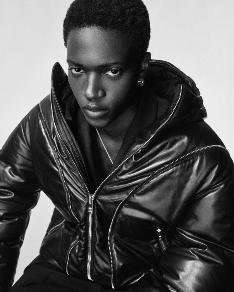Limamu Mbaye dons a leather zip puffer jacket by Versace. 
