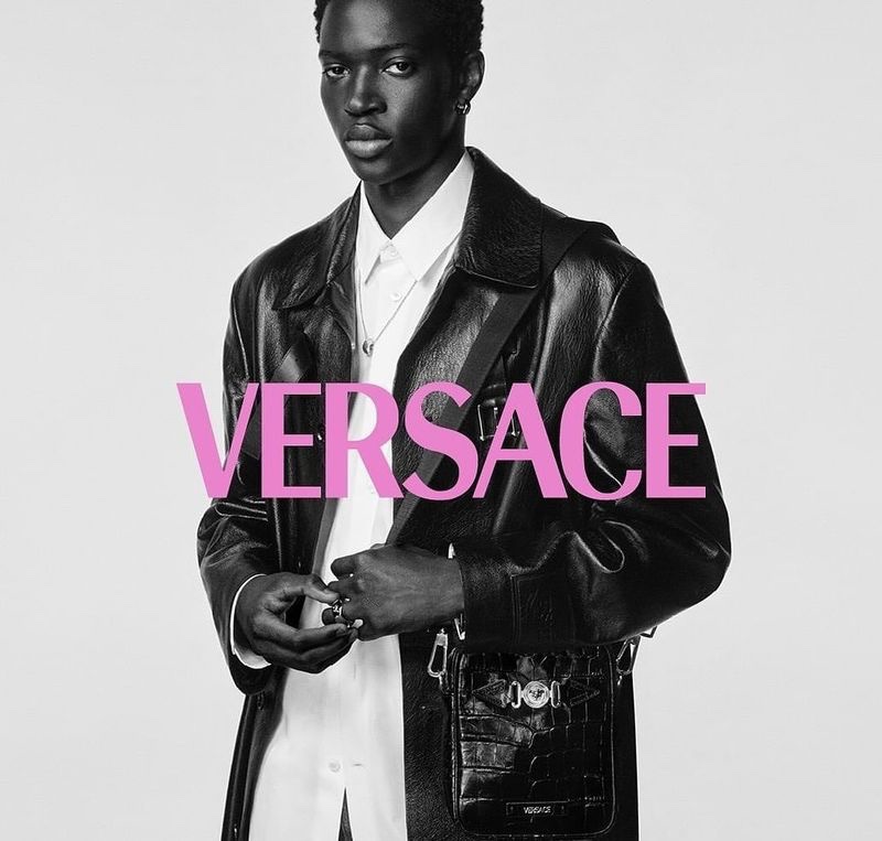 Making a luxe statement, Limamu Mbaye wears a long leather coat from Versace.
