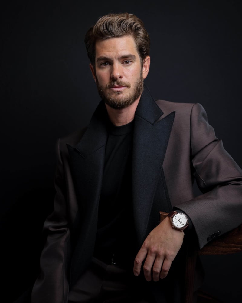 In a moment of quiet reflection, Andrew Garfield pairs his thoughtful gaze with the timeless style of an OMEGA De Ville Prestige Co-Axial Master Chronometer Power Reserve in Sedna Gold.