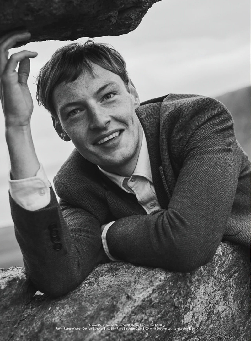 Roberto Sipos, with a candid smile, leans against a rocky outcrop, donning a classic tweed jacket that speaks to Banana Republic's timeless holiday elegance.