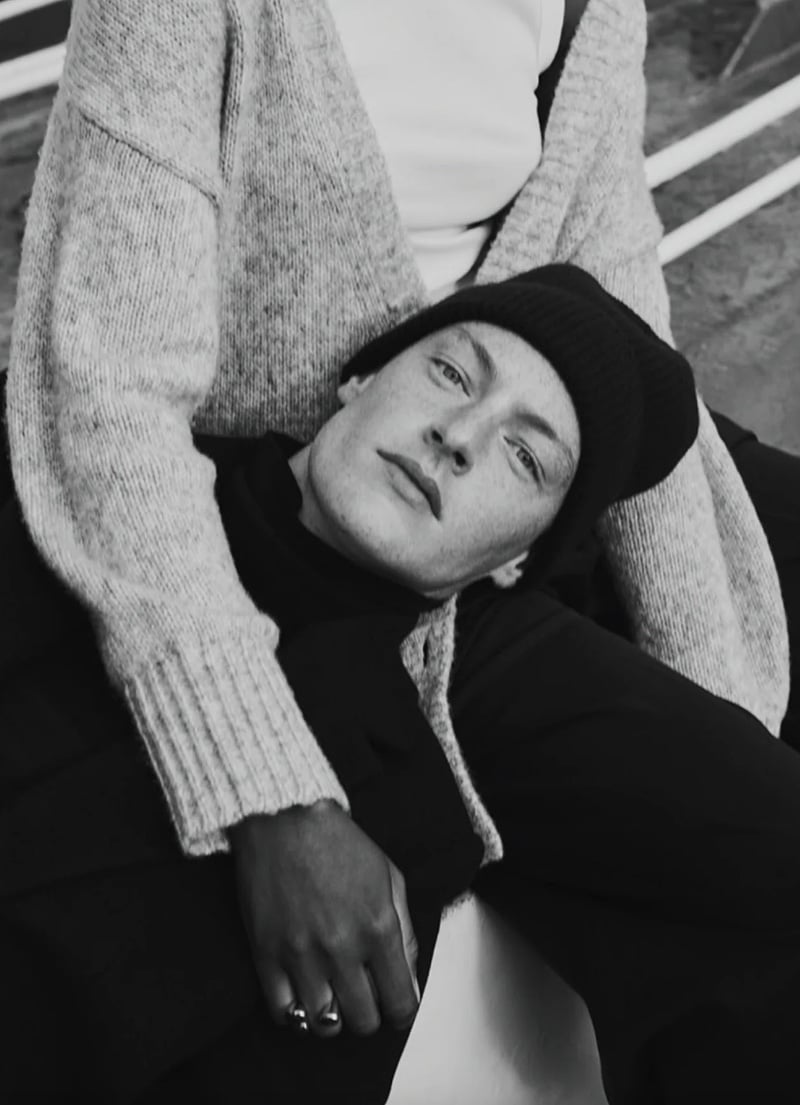 Roberto Sipos lounges in casual chic, sporting a knit beanie and a layered sweater look for Banana Republic's holiday campaign. 