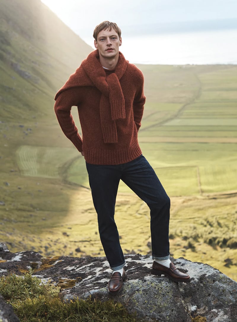 Roberto Sipos stands confidently amidst the grandeur of nature, clad in a cozy rust-colored sweater for Banana Republic's festive collection.