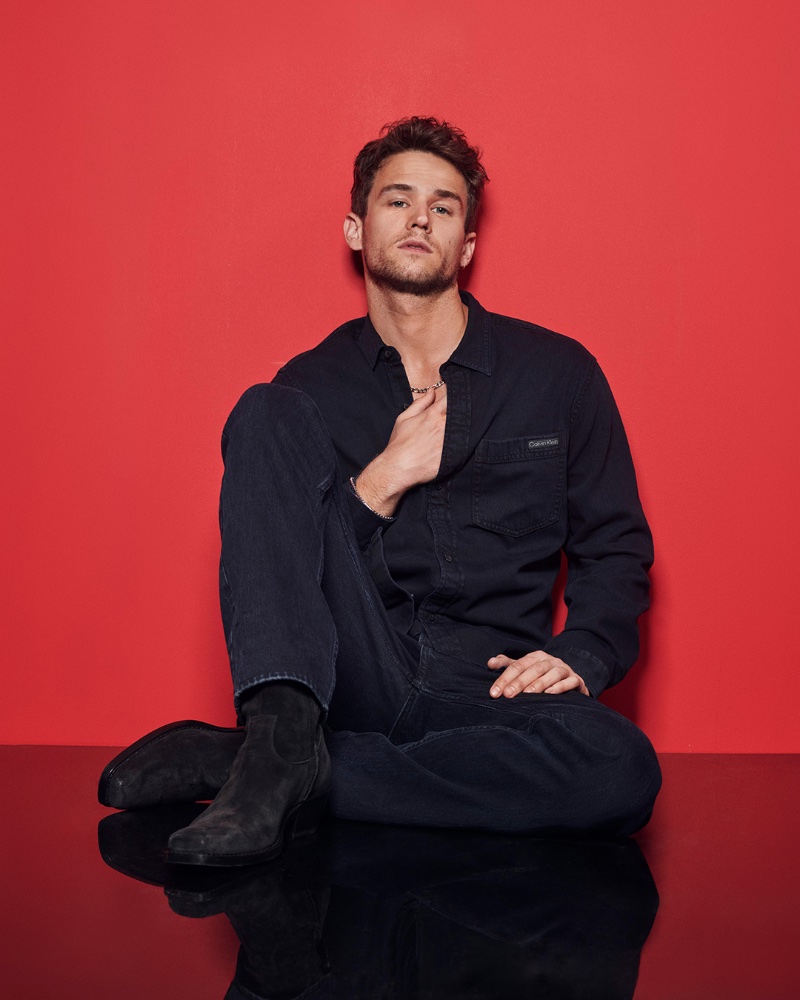 Brandon Flynn wears all black for Calvin Klein's holiday 2023 advertising campaign.