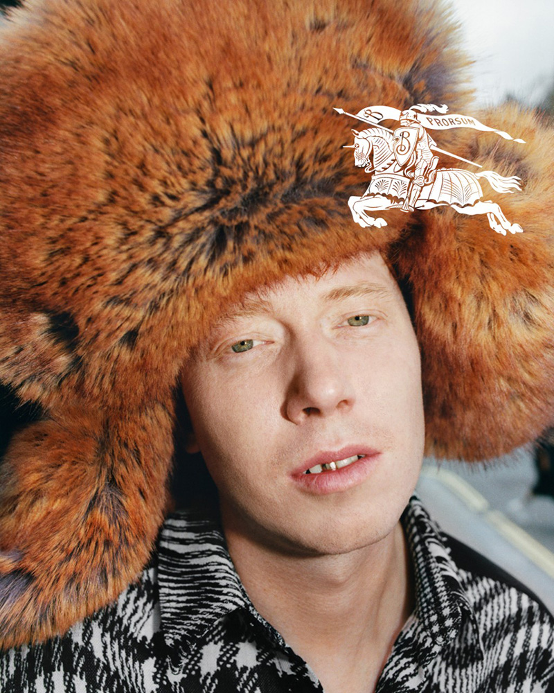 King Krule dons a bold fur hat, lending an air of avant-garde flair to the reimagined patterns of Burberry's spring 2024 collection.
