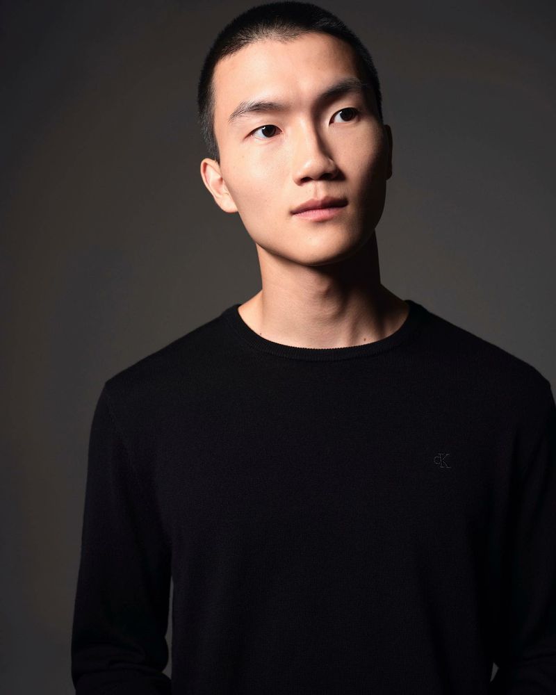 Ryan Park embraces understated elegance in a timeless black Calvin Klein sweater, embodying minimalist sophistication.