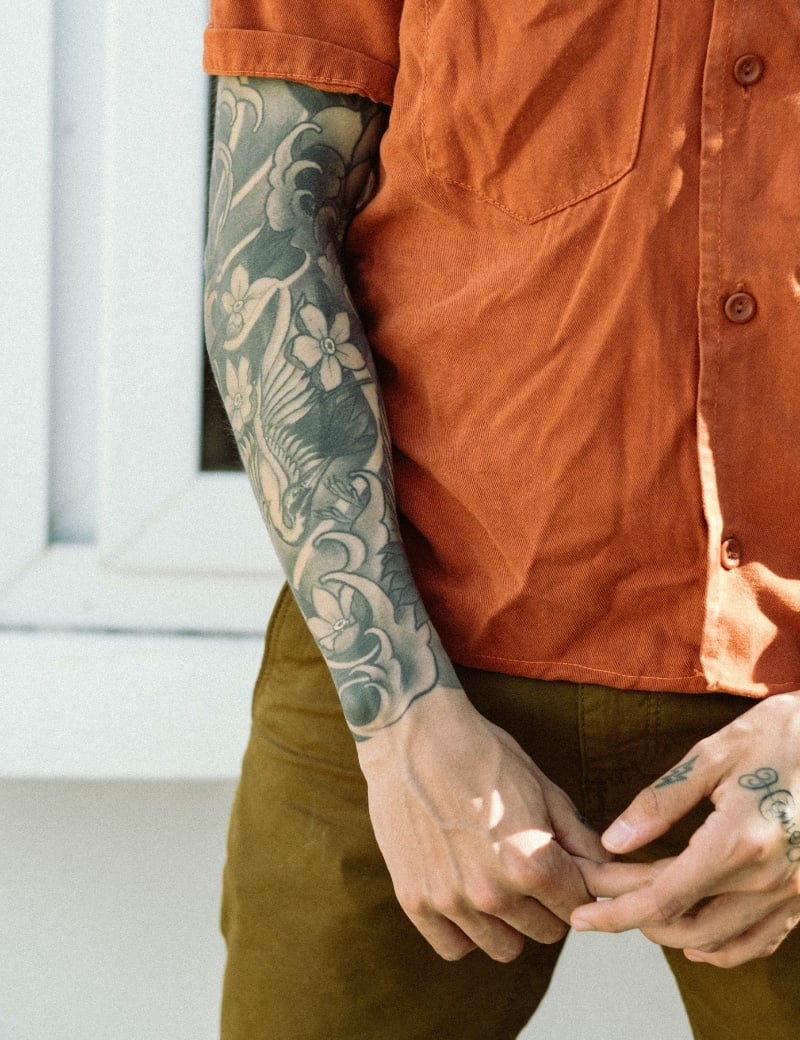 This sleeve tattoo features a floral design with the intricacies of petal and leaf, winding along the forearm.