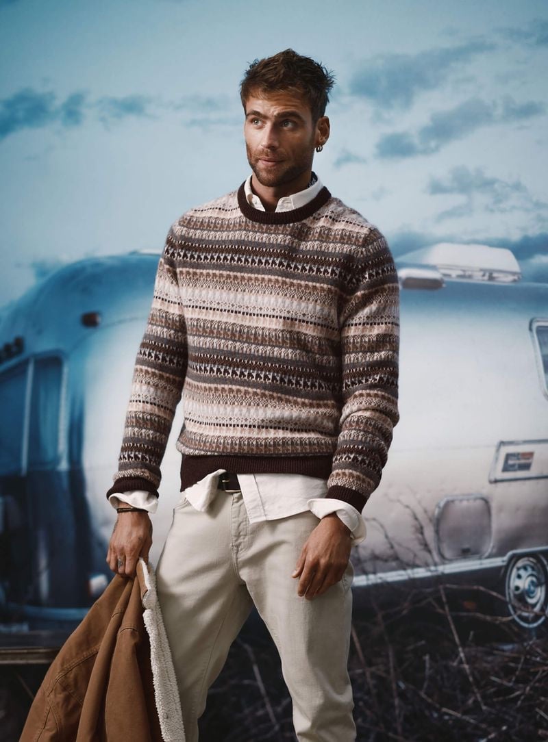 George Alsford, donning a cozy patterned sweater from Le 31, exudes a relaxed elegance.
