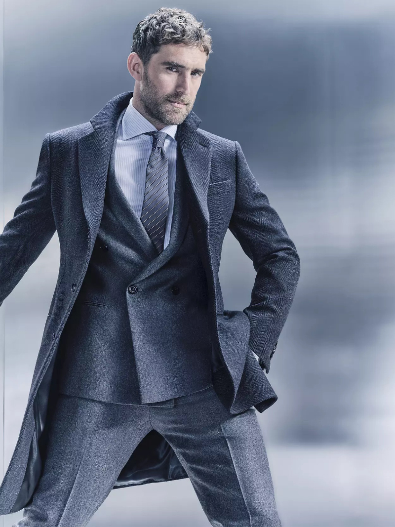 Will Chalker dons a grey coat and double-breasted suit for the Giorgio Armani Made to Measure fall-winter 2023 campaign. 