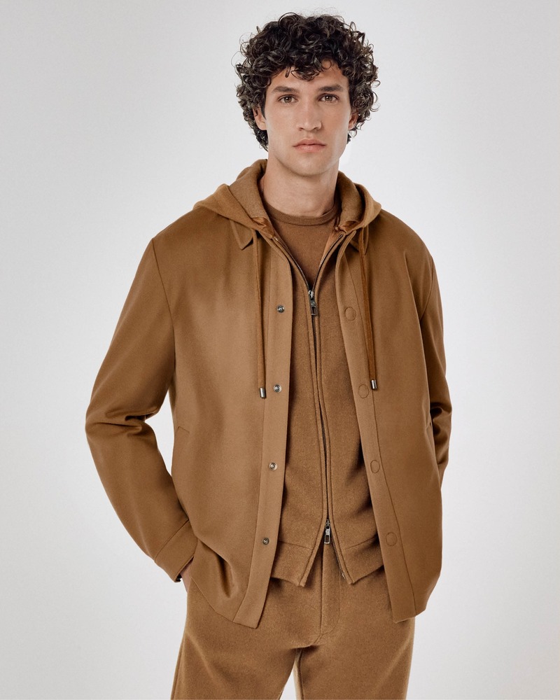  poised Francisco Henriques models a Giorgio Armani Vicuña ensemble featuring a structured jacket over a zipped hoodie, exuding casual sophistication. 