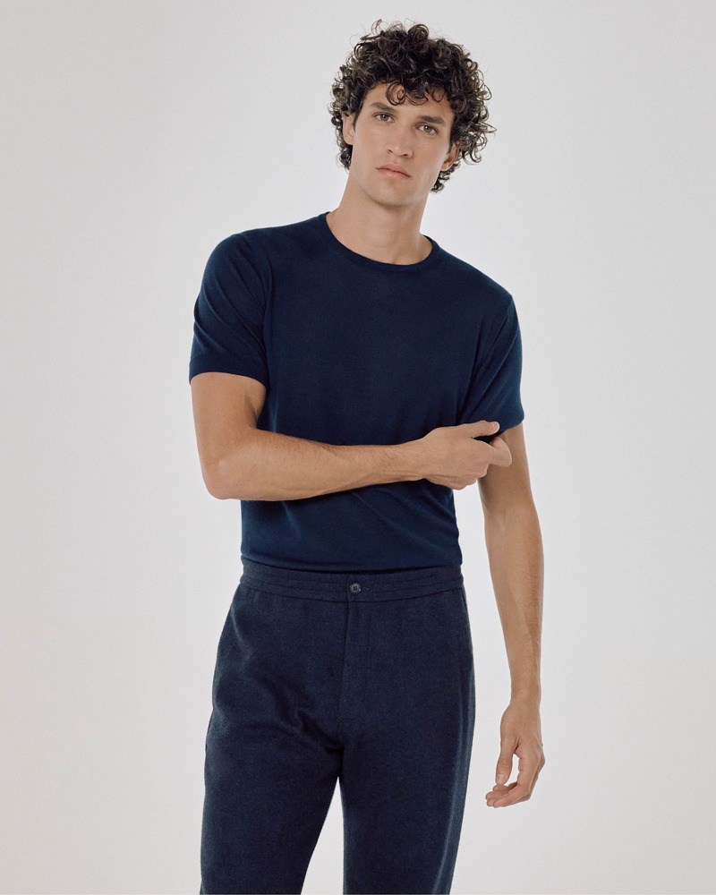 Francisco Henriques exudes effortless style in a navy blue t-shirt and coordinating wool trousers, embodying relaxed elegance.