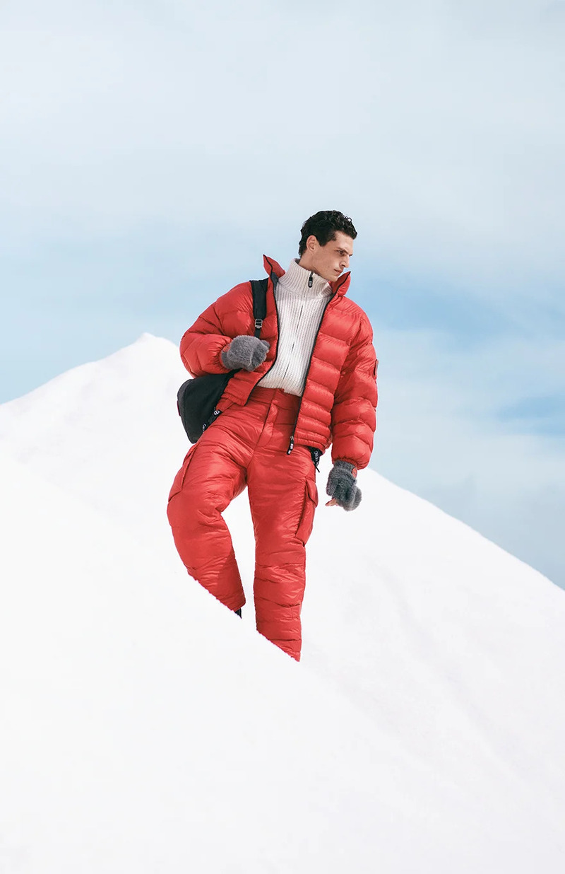 Sporting Giorgio Armani Neve, Pau Ramis cuts a striking figure against the winter landscape, sporting a bold red puffer suit paired with a classic turtleneck.
