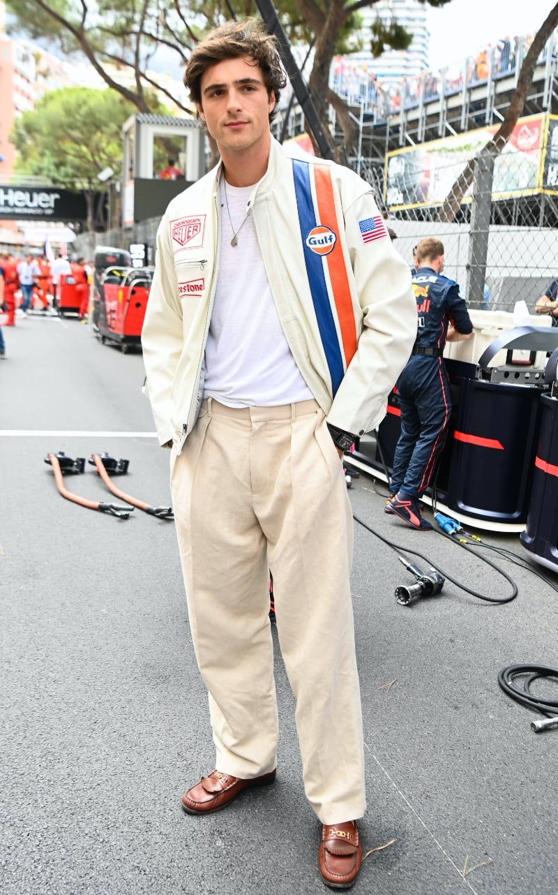 Jacob Elordi exudes a relaxed yet polished vibe at the 2022 Monaco GP, sporting a vintage-inspired racing jacket over a crisp white tee, paired with classic pleated trousers and timeless leather loafers, ready to enjoy the high-speed thrills at Circuit de Monaco.
