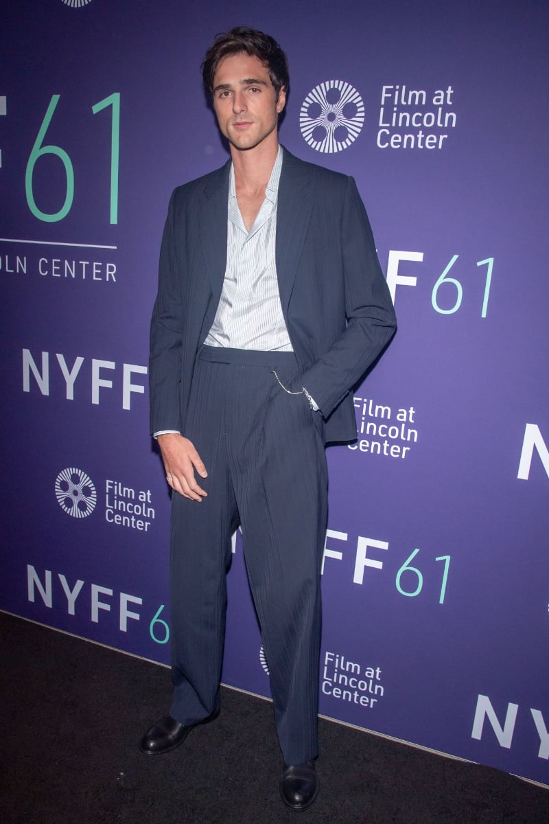 At the 61st New York Film Festival for Priscilla, Jacob Elordi commands the red carpet with understated elegance in a relaxed pinstripe suit and an unbuttoned shirt, embodying a modern take on classic suiting. 