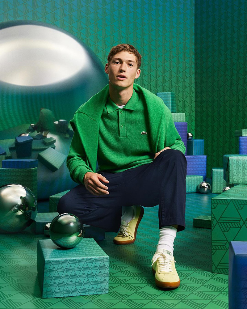 Valentin Humbroich showcases relaxed sophistication in a vibrant green Lacoste sweater, contrasting with a geometrically playful background.