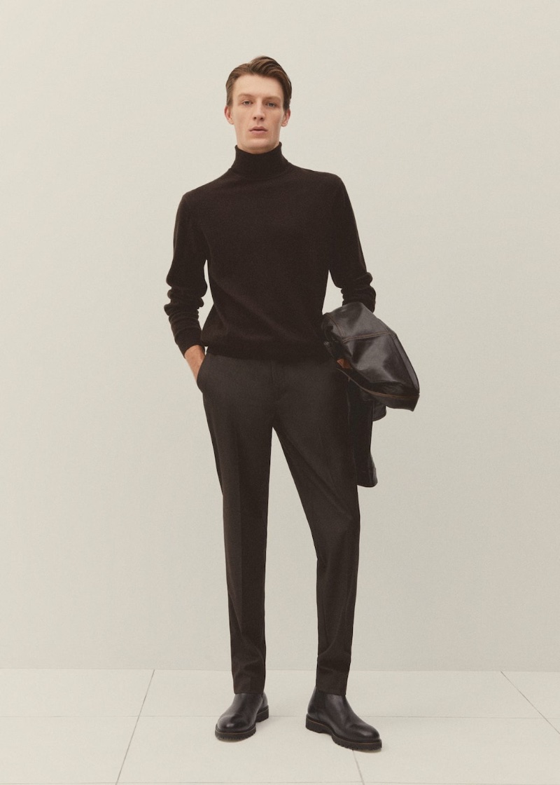 Finnlay Davis wears a turtleneck and trousers with Chelsea boots. 