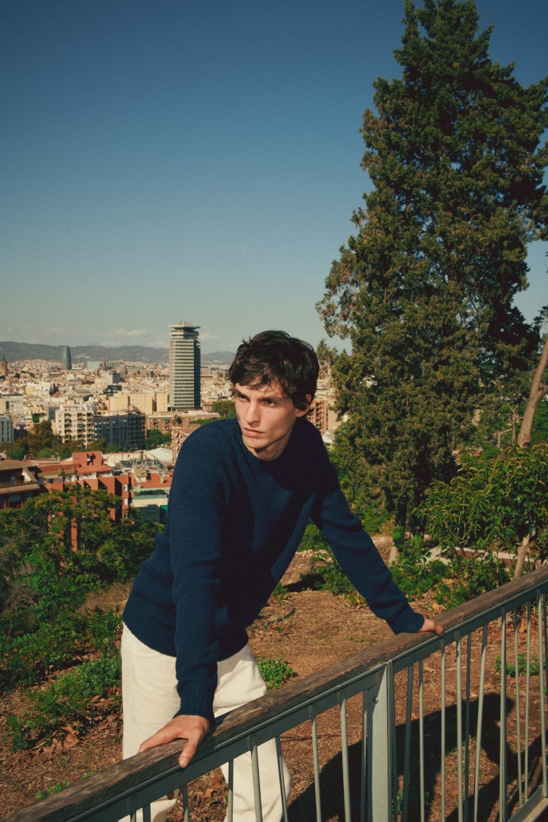 Lucas El Bali wears a navy sweater by Massimo Dutti.