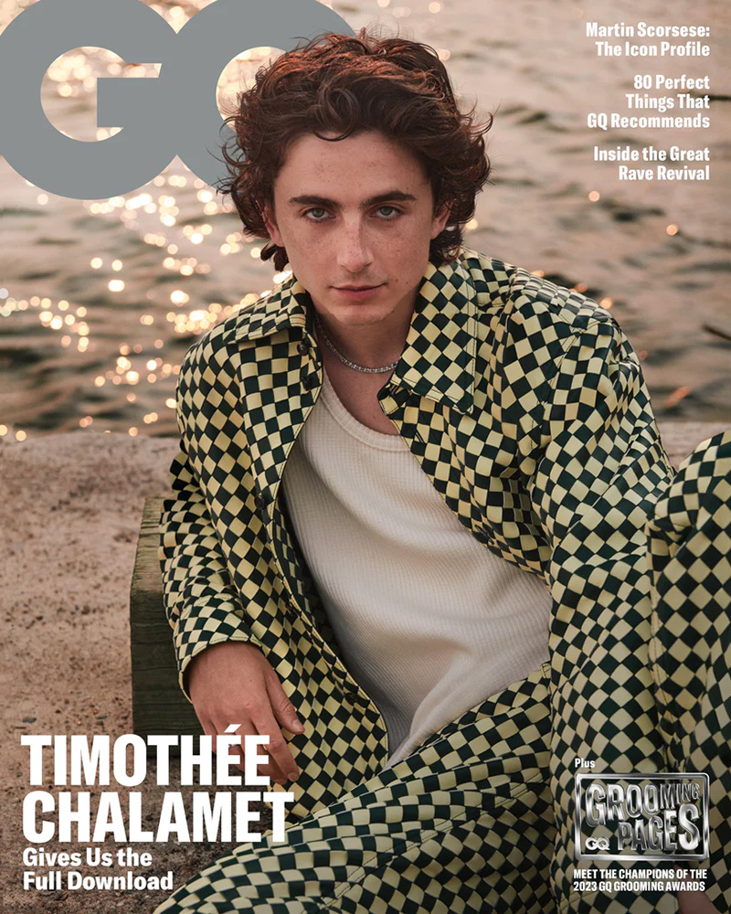 Timothée Chalamet exudes relaxed elegance in a checkered Bottega Veneta outfit, set against the serene backdrop of a sunlit water scene, on the 2023 GQ cover.