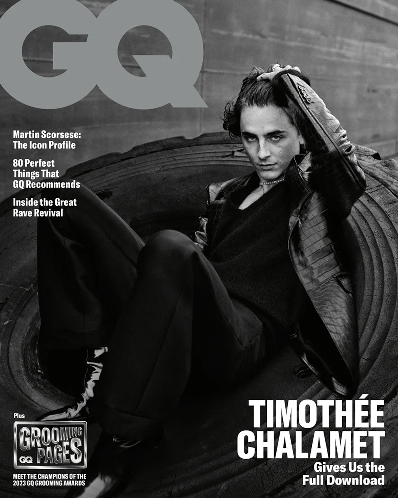 Amidst dramatic shadows, Timothée Chalamet strikes a contemplative pose on a tire, donning a leather jacket outfit by Tom Ford with Saint Laurent patent leather boots for the GQ November 2023 cover.