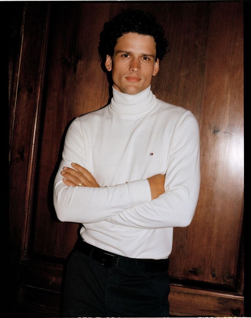 Confident and composed, Simon Nessman wears a classic white turtleneck, embodying the clean aesthetic of Tommy Hilfiger's holiday 2023 collection.