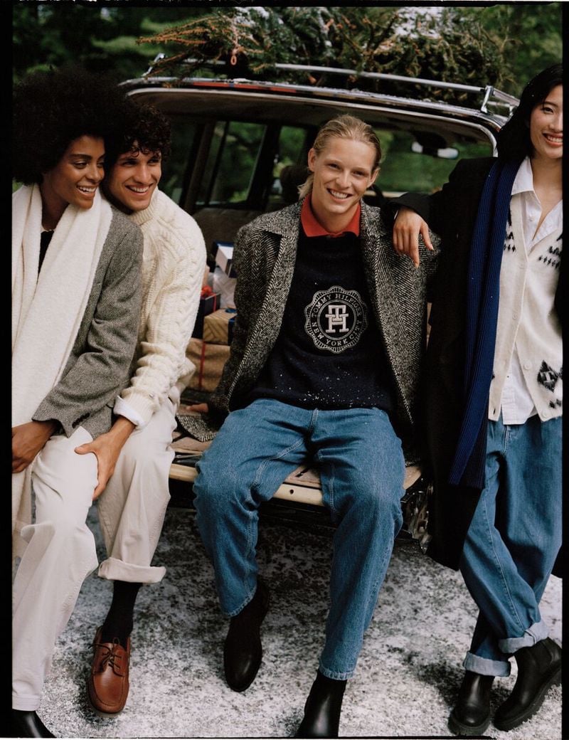 Friends, including Francisco Henriques and Luke Champion share a laugh on the tailgate of a vintage car for the Tommy Hilfiger holiday 2023 campaign. 
