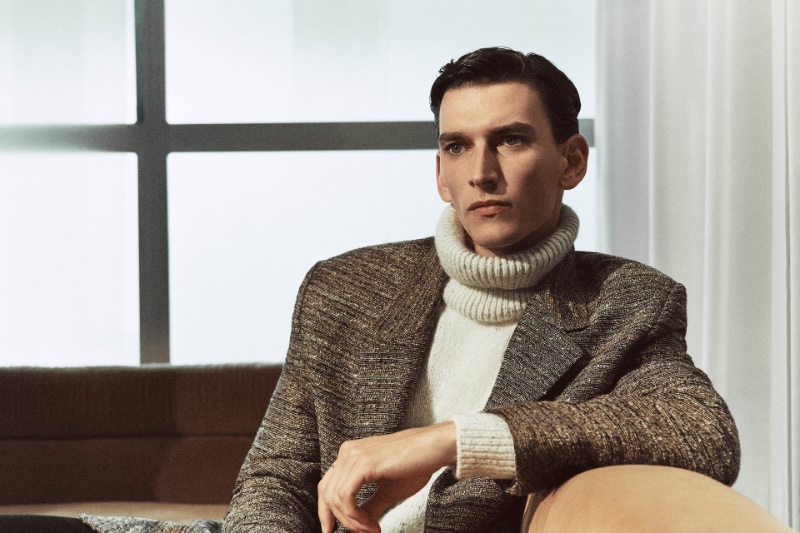 Model Thibaud Charon sits poised in a chic turtleneck and blazer ensemble from Zara Edition.