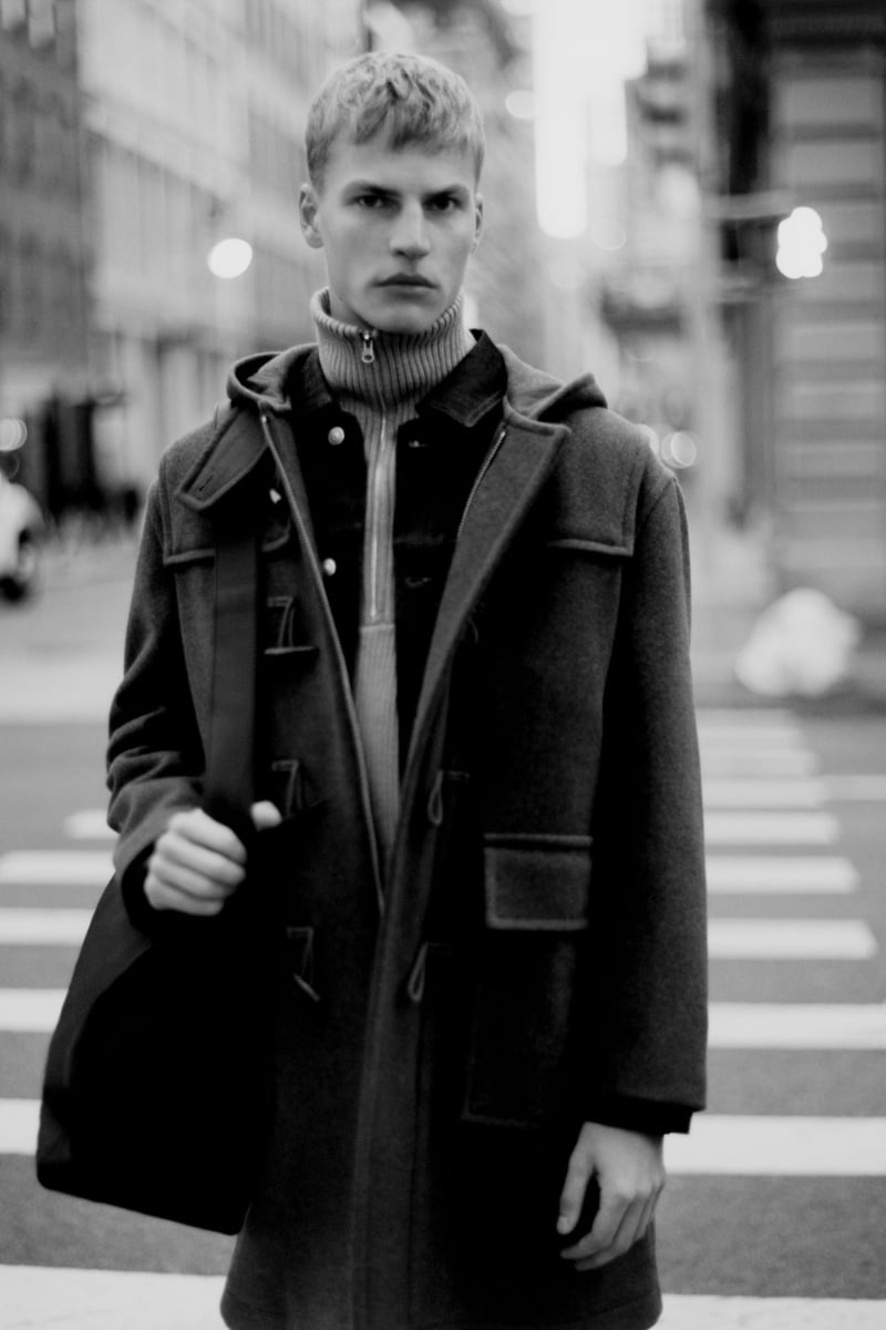 Captured on a city street, Timo Pan wears a duffle coat layered over a turtleneck. 