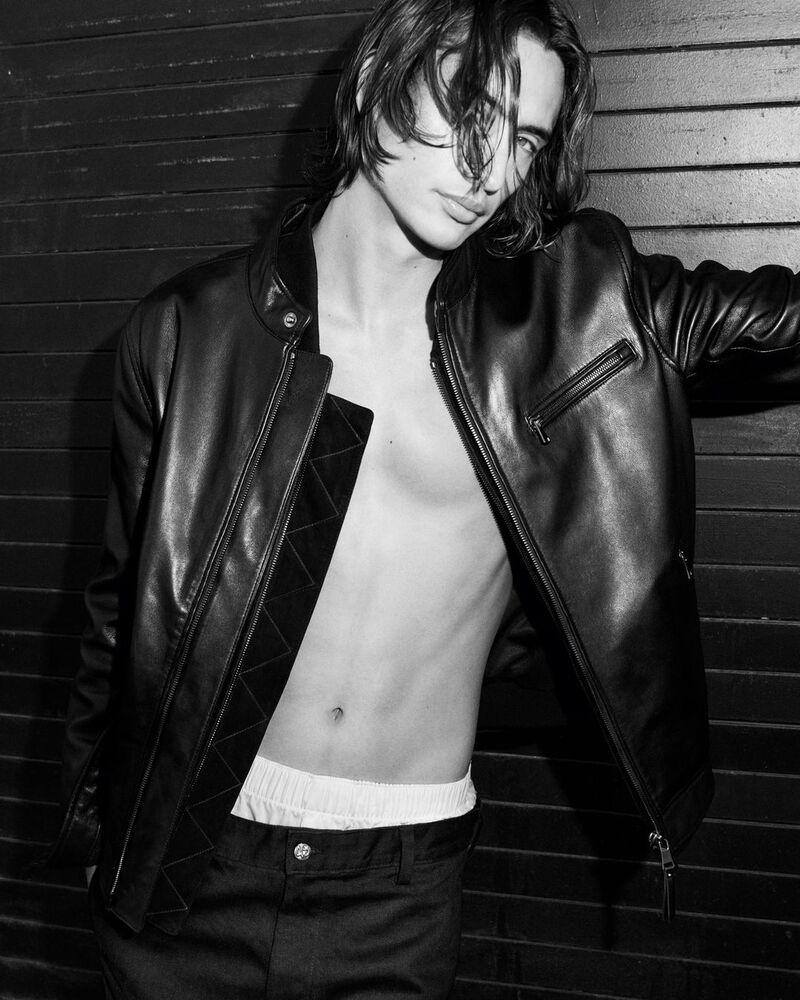 James Turlington exudes a rebellious charm in a black AG Jeans leather jacket.