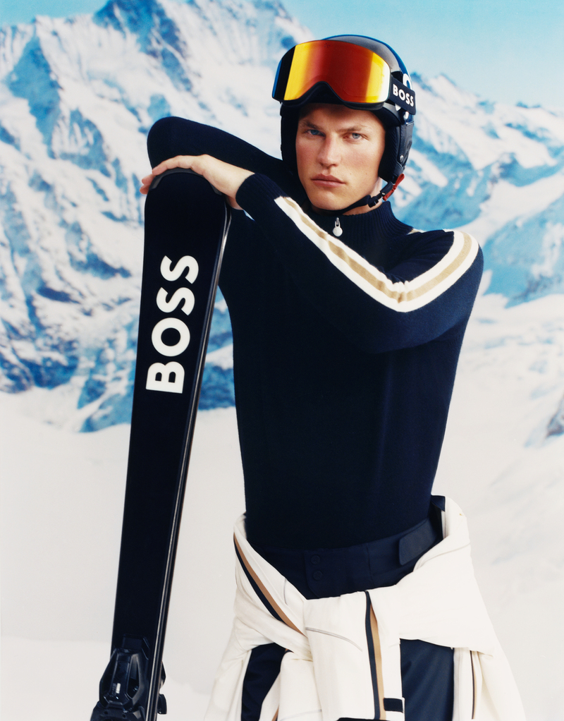 Timo Pan is ready to hit the slopes, looking sharp in a navy BOSS x Perfect Moment ski turtleneck with white stripes paired with orange-tinted ski goggles and carrying sleek BOSS skis.