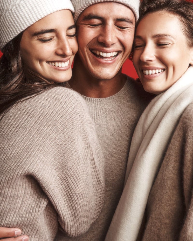 Harry Gozzett, flanked by joyous companions, wears a cozy Club Monaco knit.