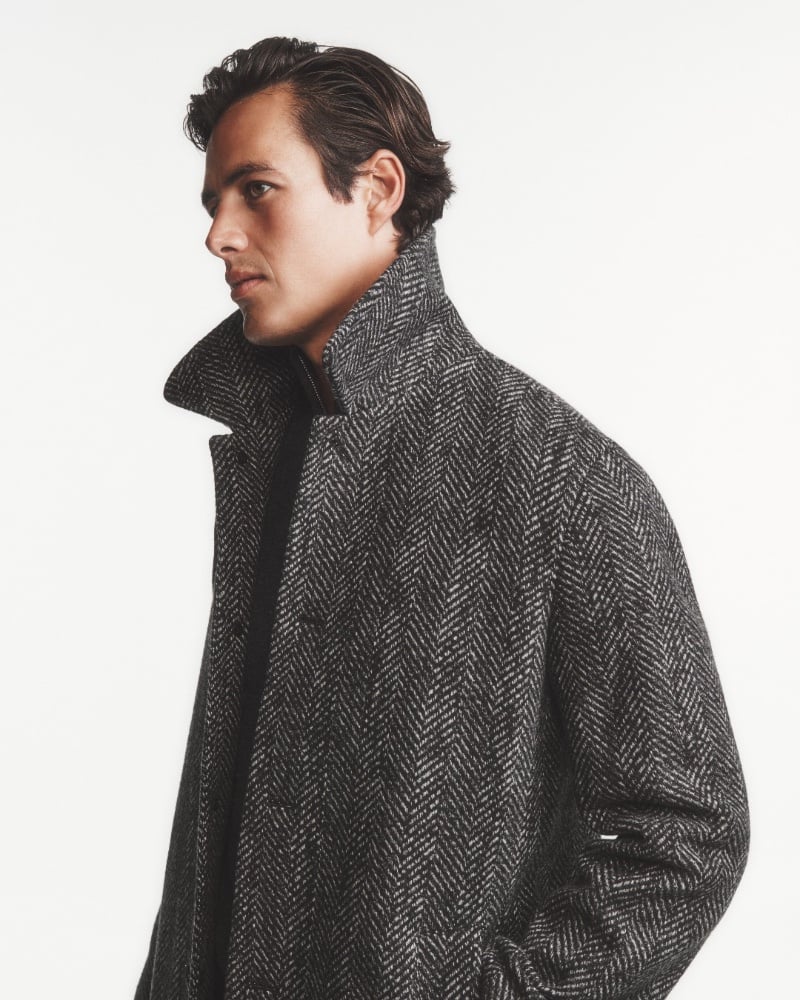Model Harry Gozzett's profile is accentuated by the collar of an elegant herringbone coat by Club Monaco.