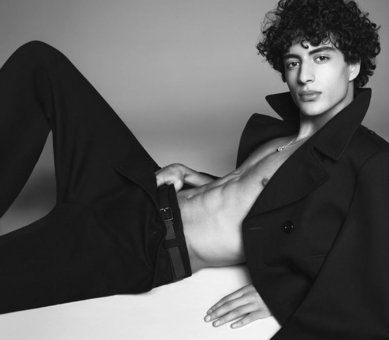 Model Yoesry Detre lounges in an open double-breasted peacoat from the Dolce & Gabbana Marina collection.