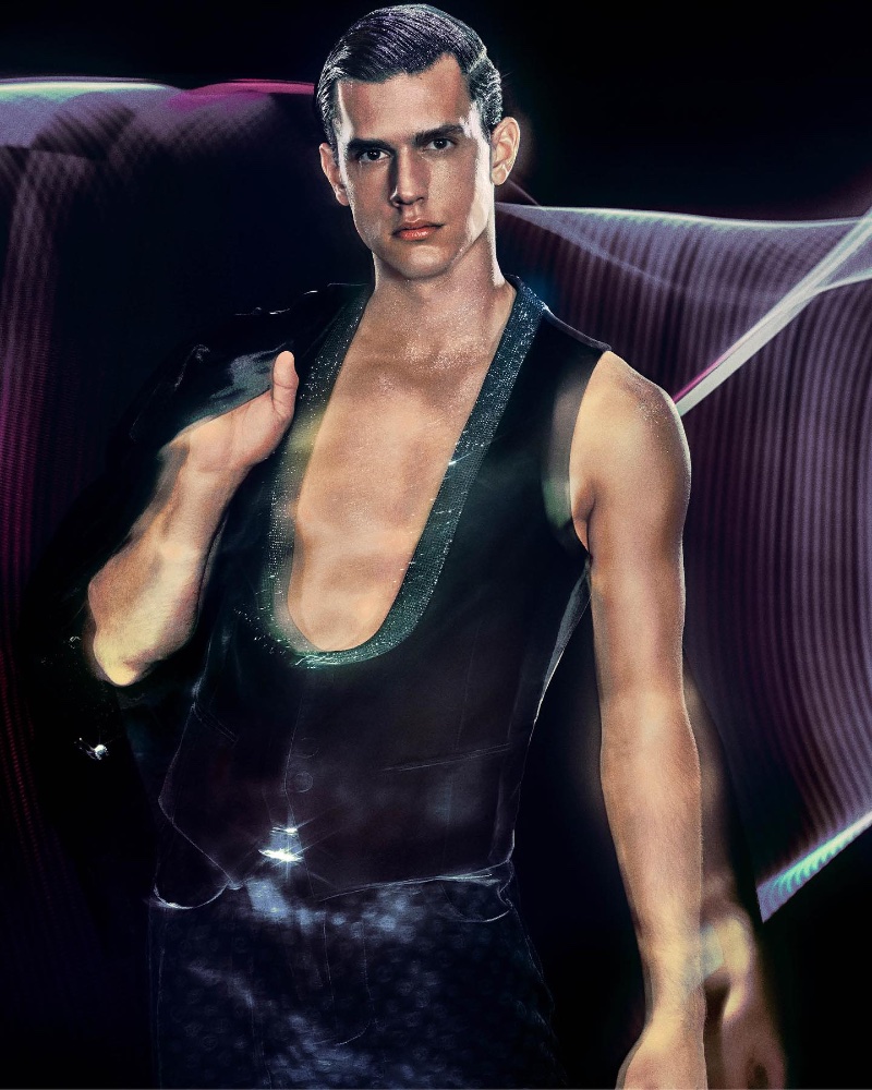 Embodying the festive spirit, Xavier Serrano dons a sleek Giorgio Armani vest, illuminated by stylized lighting for the holiday 2023 campaign.