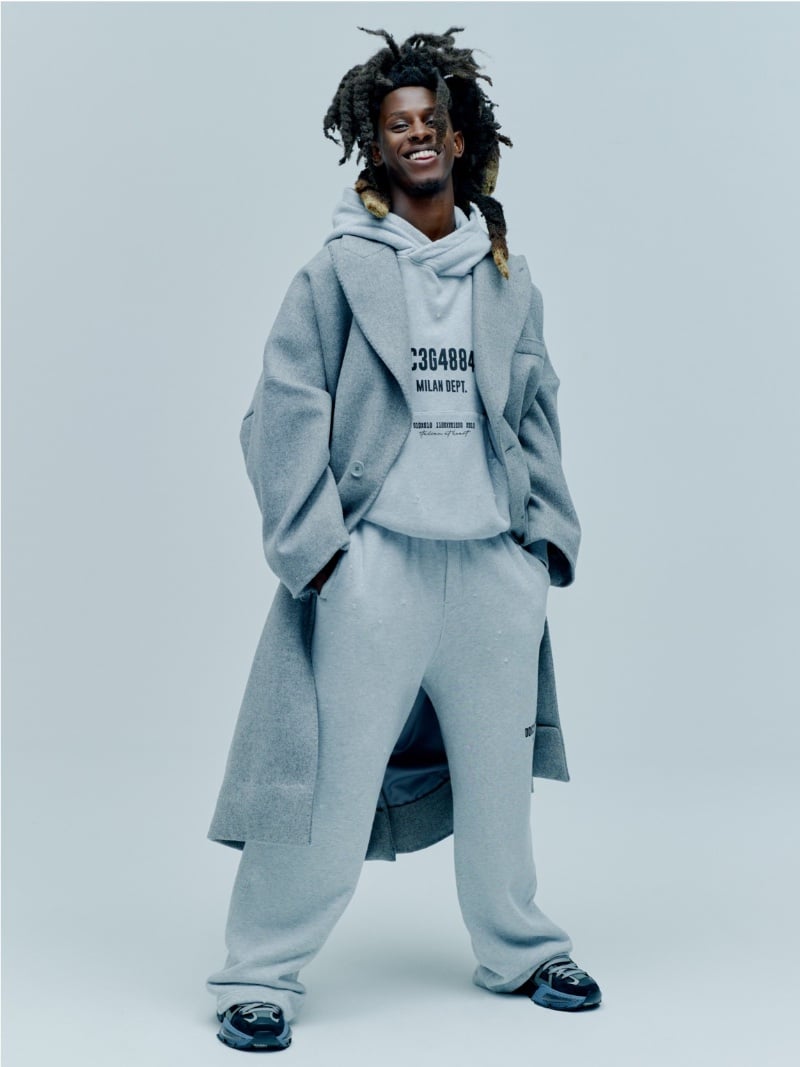 All smiles, Bill wears a Dolce & Gabbana wool oversized long coat with a cotton hoodie and sweatpants.