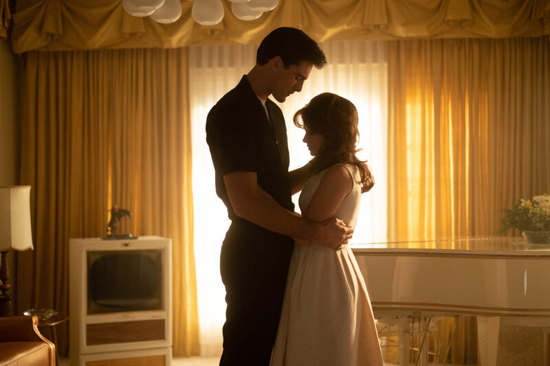 Jacob Elordi shares an intimate dance with a partner in a softly lit room, their silhouettes bathed in the golden hue of the setting sun filtering through sheer curtains.