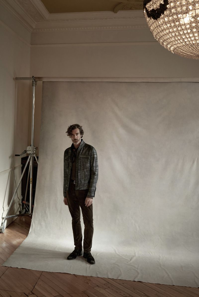 A poised Richard Biedul in a tailored plaid jacket and dark trousers, exuding a casual sophistication during a photoshoot.