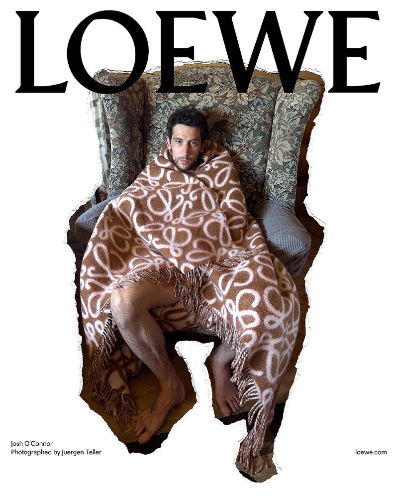 Wrapped in a patterned Loewe blanket, Josh O'Connor appears in the brand's pre-spring 2024 campaign.