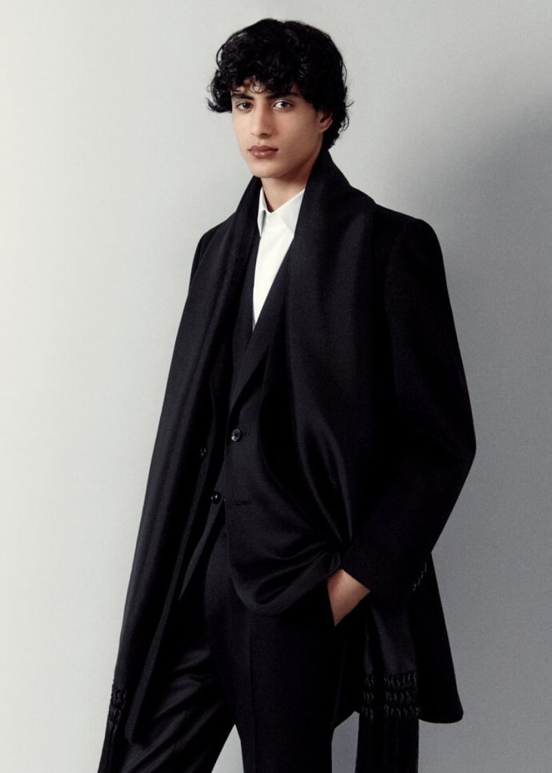 A sharp vision, Yoesry Detre dons a tailored black coat over a suit by Loro Piana.